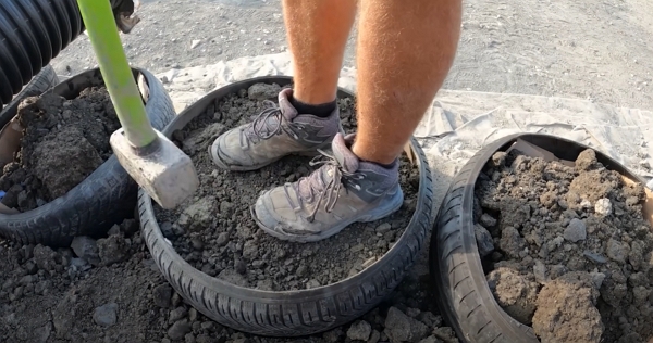 Un pneu en cours de remplissage de terre