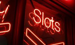 Un panneau rouge indiquant « Slots » dans l’obscurité.