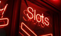 Un panneau rouge indiquant «\u00a0Slots\u00a0» dans l’obscurité.