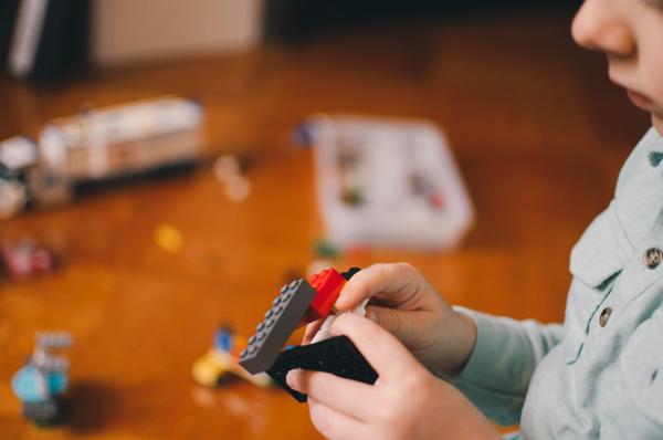 Un enfant construit quelque chose avec des blocs LEGO.