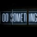 Un panneau « Do Something Great » dans l'obscurité