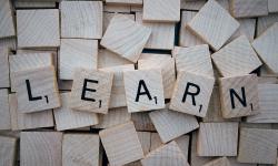 Lettres de scrabble formant le mot « apprendre » en anglais