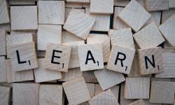 Lettres de scrabble formant le mot « apprendre » en anglais