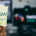Une personne tenant un post-it avec “Python” écrit dessus