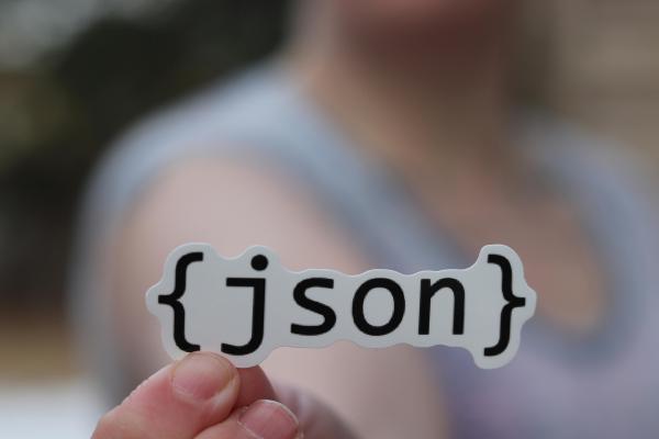 Un autocollant JSON dans la main d’une personne