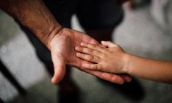 Une main d'enfant sur celle d'un adulte