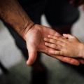 Une main d'enfant sur celle d'un adulte Une main d'enfant sur celle d'un adulte
