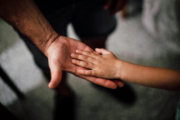 Une main d'enfant sur celle d'un adulte