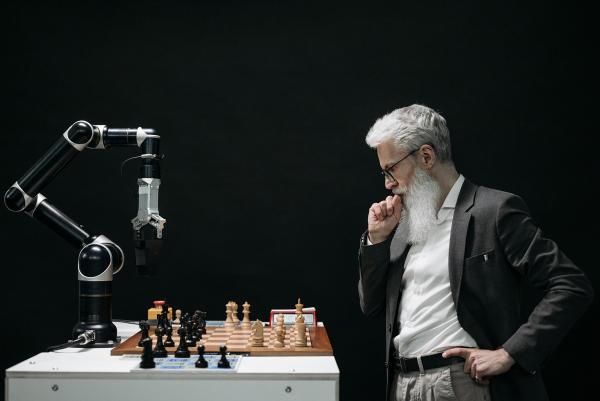 Un homme jouant aux échecs avec un robot