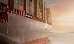 Un porte-conteneurs naviguant vers le lever du soleil.