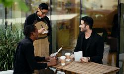 Un serveur prenant la commande de deux hommes