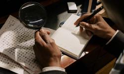 Un homme avec une loupe déchiffrant des symboles