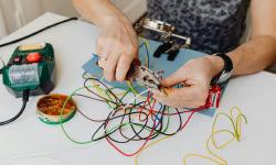 un homme travaillant sur un circuit électrique